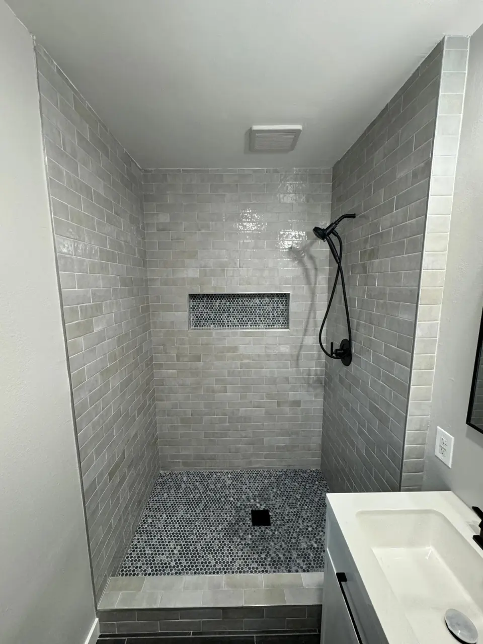 small shower with sink next to it